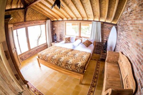 a bedroom with a bed in a brick wall at Batu Hill Villa in Watukarung