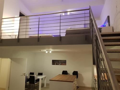 a room with a table and a staircase with a table and chairs at WH Boardinghouse in Papenburg