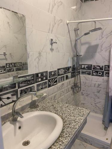 a white bathroom with a sink and a shower at Senmut Luxory Apartments in Luxor