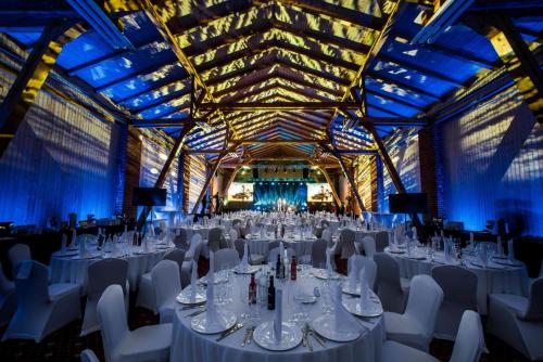 a banquet hall with white tables and white chairs at Hotel Sobienie Królewskie in Sobienie Szlacheckie