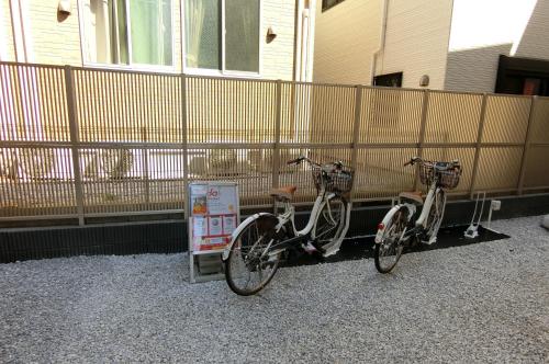 two bikes are parked next to a fence at plat hostel keikyu haneda home in Tokyo