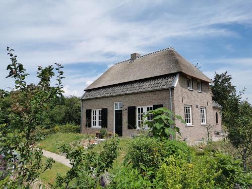 une ancienne maison en briques avec un toit gris dans l'établissement Natuurlijk Genieten, à Bemmel