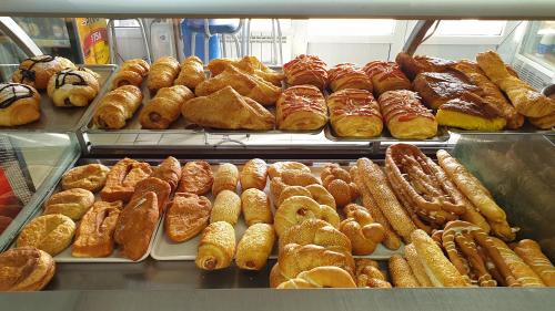 a display case filled with lots of different types of pastries at Lovely Private Flats FREE parking in Novi Sad