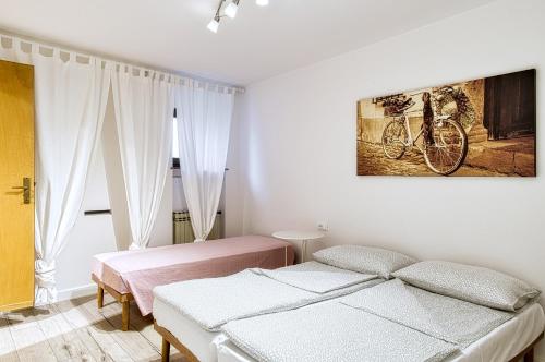 1 dormitorio con 2 camas y una pintura en bicicleta en la pared en Casa Raffaele, en Malcesine