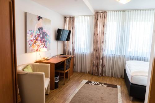 a hotel room with a desk and a bed at Hotel Bürger in Siegen