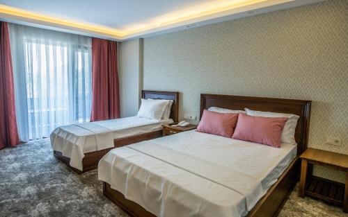 Кровать или кровати в номере Helen Troya Hotel Geyikli