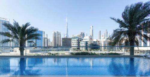 a swimming pool with a city skyline in the background at GuestReady - Modern Apartment with Gorgeous Views in Dubai