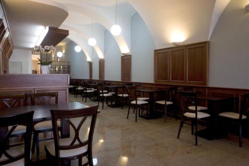 a row of tables and chairs in a restaurant at Hostel U Zlatého kohouta in Kroměříž