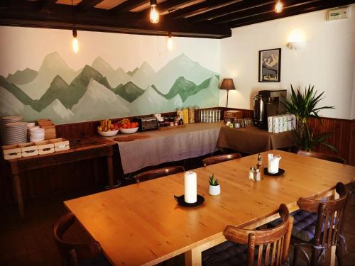 ein Esszimmer mit einem Tisch und Stühlen sowie eine Küche in der Unterkunft Hotel Au Bon Accueil in Les Deux Alpes
