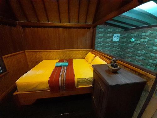 a small bed in a room with a table at Tetebatu Valley Bungalows in Tetebatu