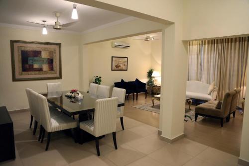 a dining room and living room with a table and chairs at Butterfly Guest House Phase 7 Bahria Town in Rawalpindi