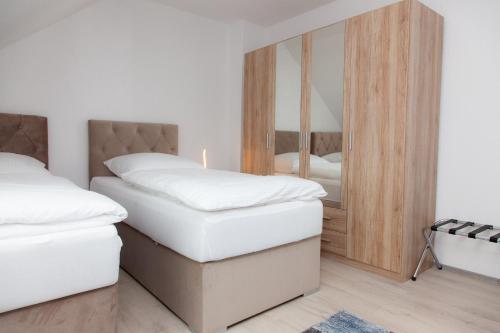 a bedroom with two beds and a mirror at T&K Apartments near Messe Fair Trade Düsseldorf und Airport 3A in Duisburg
