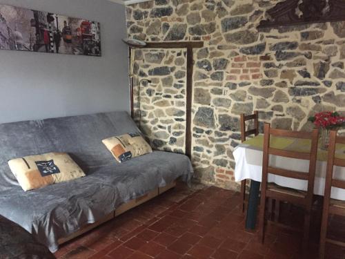 a bedroom with a bed and a stone wall at Le Clergite in Clairfayts