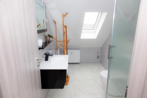 a bathroom with a sink and a skylight at T&K Apartments near Messe Fair Trade Düsseldorf und Airport 3A in Duisburg