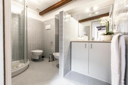 bagno bianco con lavandino e servizi igienici di San Pantalon Luxury Penthouse R&R a Venezia