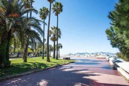 una calle con palmeras al lado de una carretera en Cozy Studio on Bd Croisette-AC- BeachesCongress by Olidesi, en Cannes