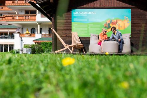 a man and woman sitting on a couch on a billboard at Sepp & Hannis Suiten im Dorf in Neustift im Stubaital