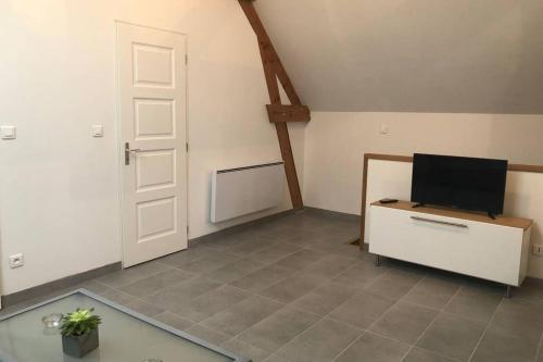 Cette chambre dispose d'une porte et d'une télévision sur un bureau. dans l'établissement la petite loge, à Ay