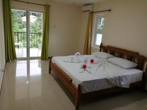 a bedroom with a bed with flowers on it at Jaidss Holiday Apartments 1 in Mahe