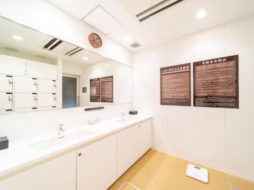 a bathroom with two sinks and a large mirror at Super Hotel Shinagawa Shinbanba in Tokyo