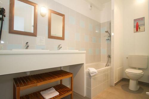 a bathroom with a sink and a toilet and a tub at Hôtel Le Vert Bois in Dolus d'Oléron