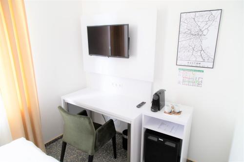a white desk with a phone and a chair in a room at Amplidi Hotel Hannover in Hannover
