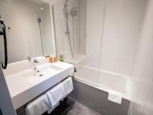 a white bathroom with a sink and a shower at greet Hotel Beaune in Beaune