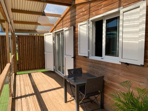 a patio with a table and two windows at thomlocation in Saint-Paul