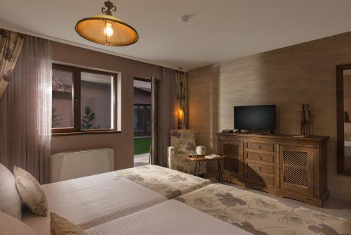 a bedroom with a bed and a flat screen tv at Zaara Estate Winery Hotel & SPA in Glavan
