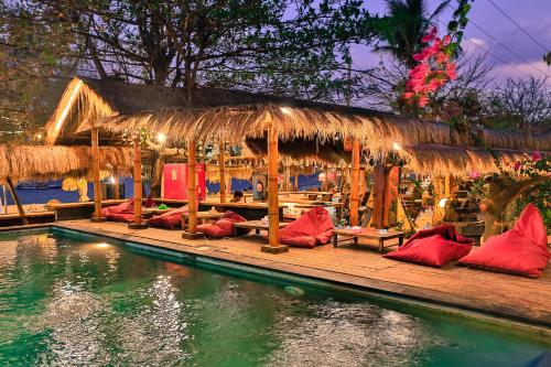 a restaurant with red pillows on a dock next to the water at Villa Bulan Madu Gili Air in Senaru