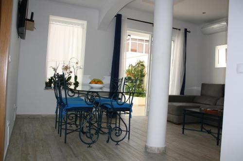 a dining room with a table and blue chairs at House of Orchids with Pátio in Vila Real de Santo António