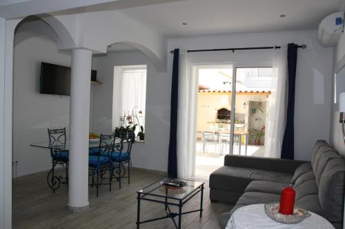 a living room with a couch and a table at House of Orchids with Pátio in Vila Real de Santo António