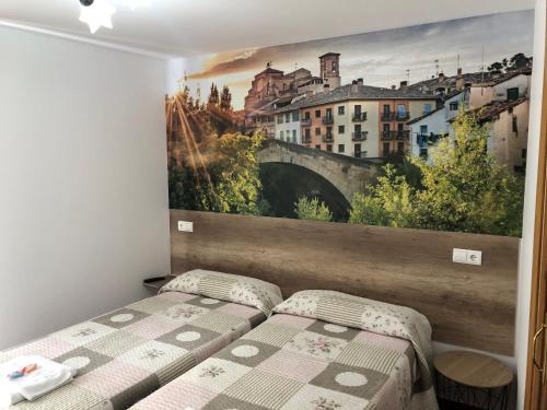 洛斯阿爾科斯的住宿－Pensión Mavi，一间卧室设有两张床,墙上挂着一幅画