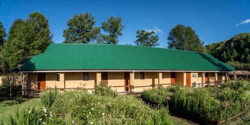 a green roofed house with a green roof at Gooderson Drakensberg Gardens Golf & Spa Resort in Drakensberg Garden
