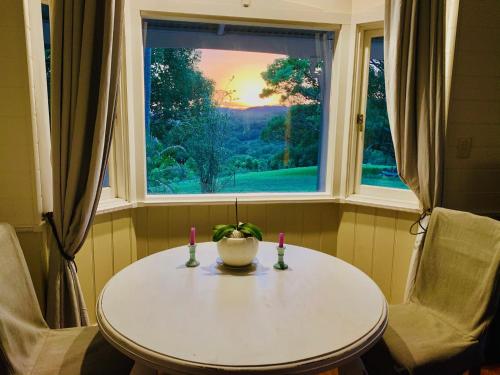 einen Tisch und Stühle in einem Zimmer mit Fenster in der Unterkunft Valleydale cottage in Goonengerry