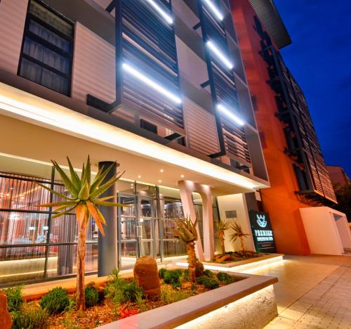 a building with palm trees in front of it at Premier Splendid Inn Bloemfontein in Bloemfontein