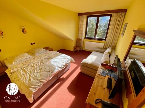 a bedroom with a bed and a couch at Hotel Ondras z Beskyd in Ostravice