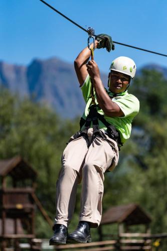 a man on a zip line in the air at Gooderson Drakensberg Gardens Golf & Spa Resort in Drakensberg Garden