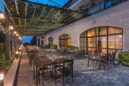 an outdoor patio with tables and chairs and lights at Zaara Estate Winery Hotel & SPA in Glavan