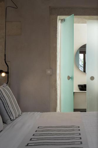 a bedroom with a white bed and a mirror at Sutor Chic Manor hotel in Rethymno Town