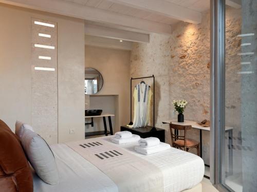 a bedroom with a white bed and a table at Sutor Chic Manor hotel in Rethymno Town
