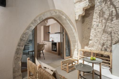 an archway in a living room with a table and chairs at Sutor Chic Manor hotel in Rethymno Town