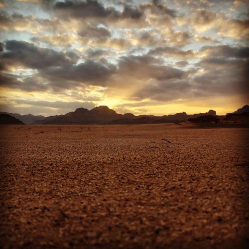 a view of a desert with a cloudy sky at Sand Star Camp in Wadi Rum