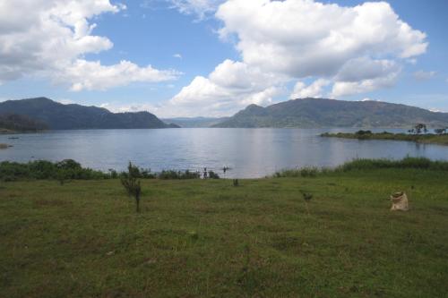 une grande étendue d'eau avec des montagnes en arrière-plan dans l'établissement Imuhira Campsites&CBT, à Macuba