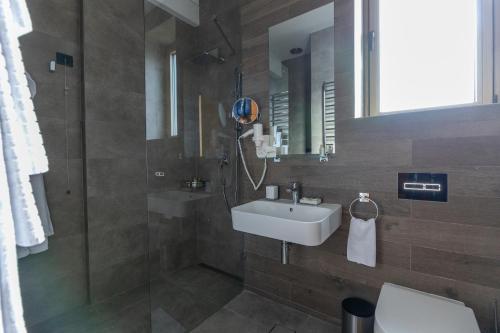a bathroom with a sink and a toilet and a mirror at Hotel Ramonda in Boljevac