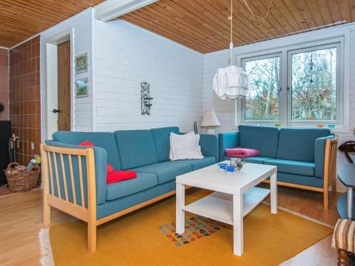 a living room with a blue couch and a table at 6 person holiday home in Glesborg in Glesborg