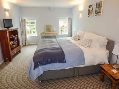 a bedroom with a large bed and a television at Garden Cottage in Richmond