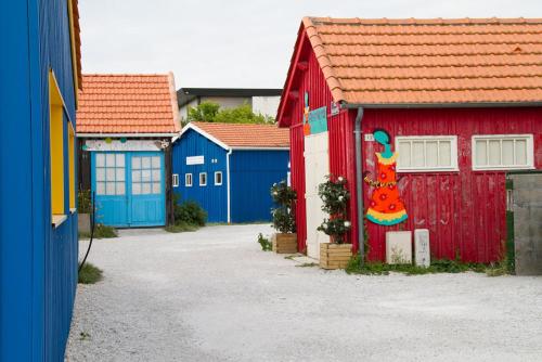 a row ofsheds with a painting of a chicken on them at Hôtel Le Vert Bois in Dolus d'Oléron
