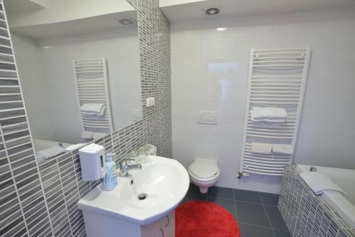 a white bathroom with a sink and a toilet at Penzion Best in Moravská Třebová