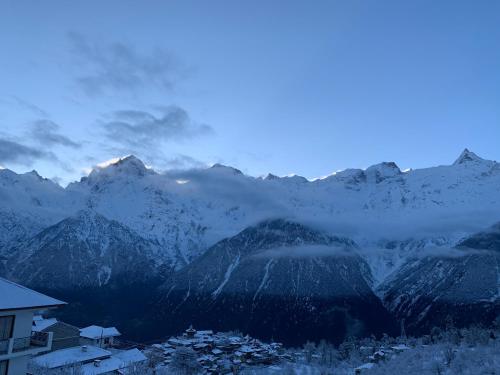 a view of a mountain range with snow covered mountains at Hotel Rollingrang in Kalpa